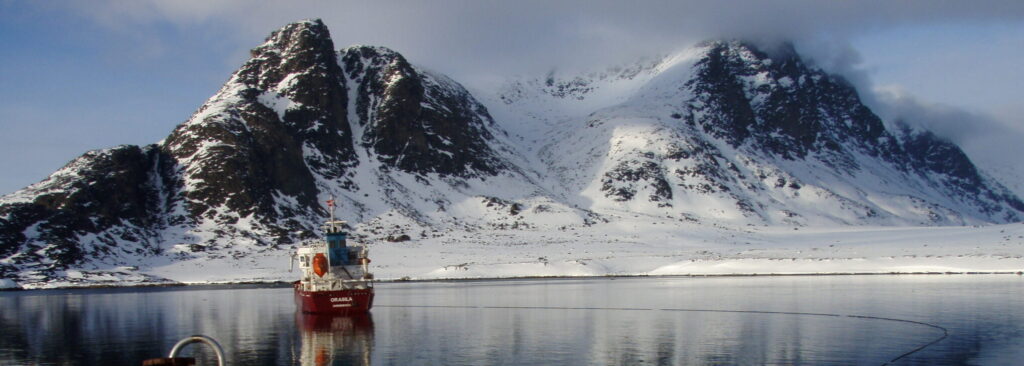 Billede af skib og bjerge i baggrunden - en skibsfører, der er ude og se verden.